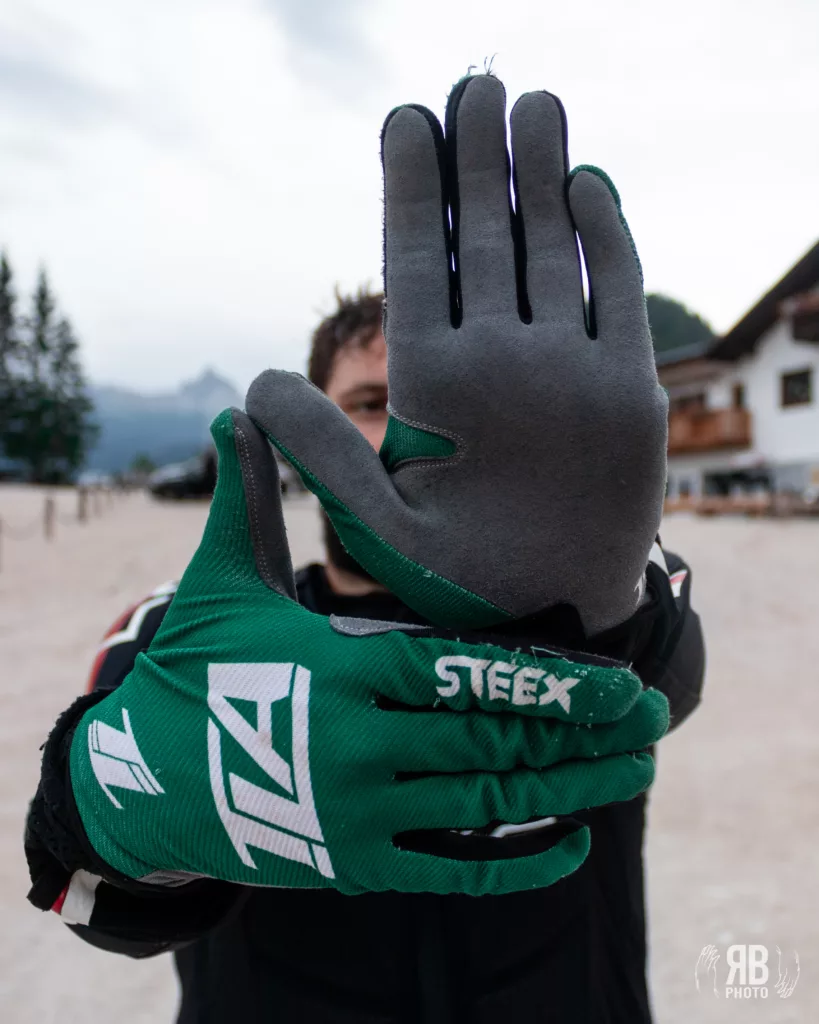 mountain biker che mostra i guanti da MTB per divertirsi in sicurezza