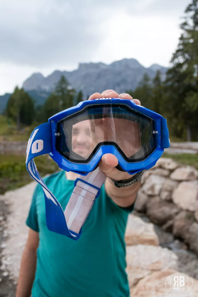 mountain biker che mostra una mascherina da motocross per divertirsi in sicurezza in discesa